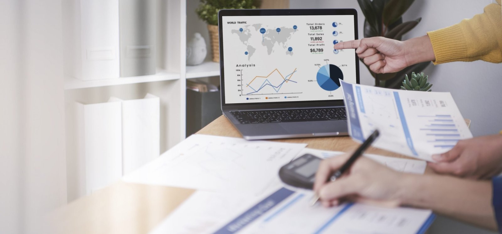 Profissionais analisando relatórios financeiros e gráficos de estoque em um notebook