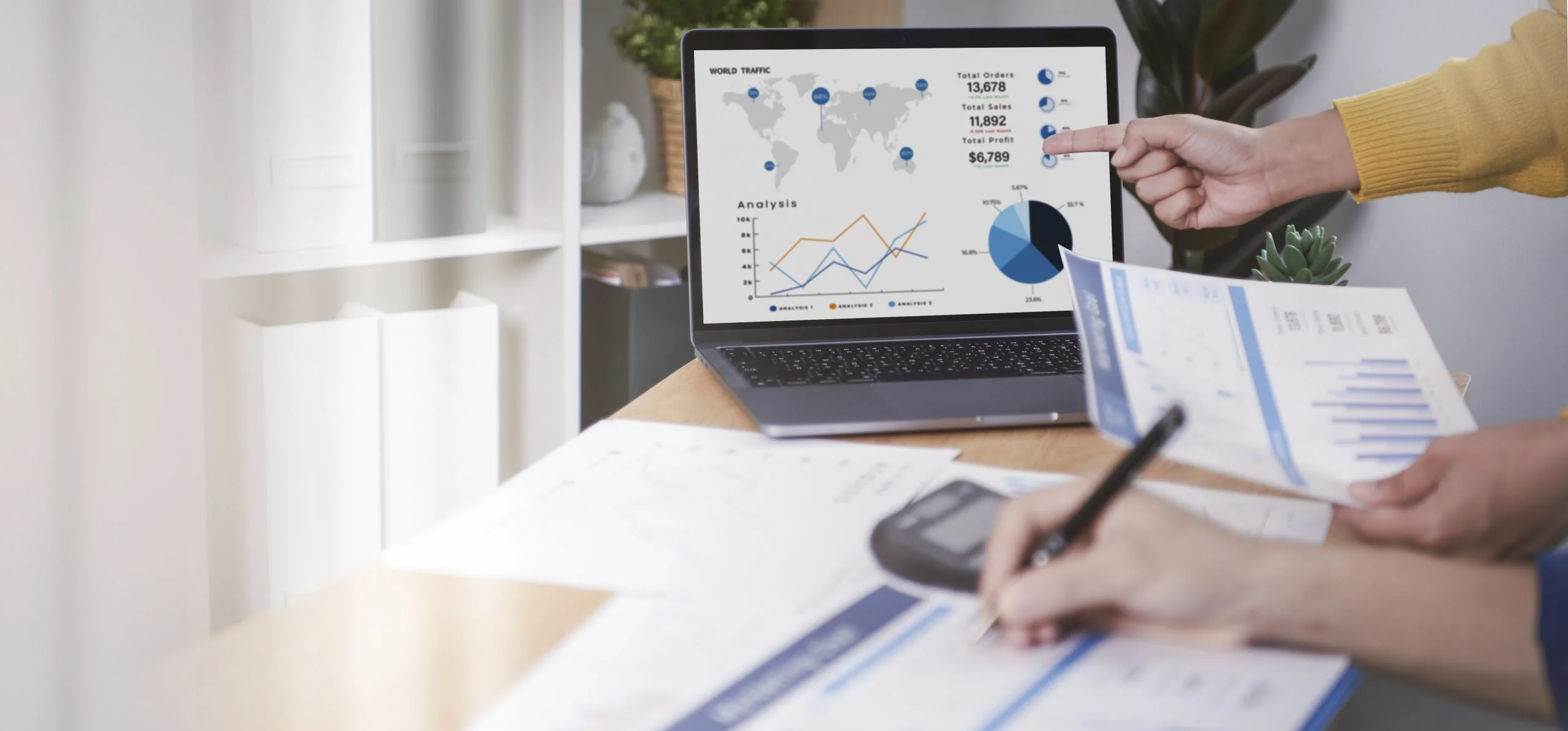 Profissionais analisando relatórios financeiros e gráficos de estoque em um notebook