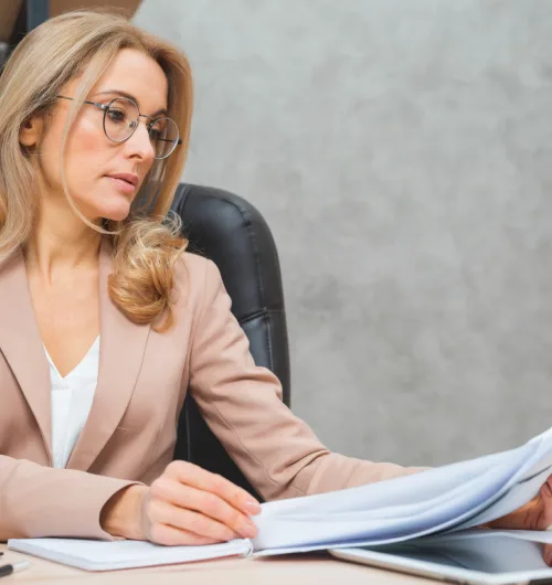 Mulher analisando documentos fiscais em ambiente corporativo